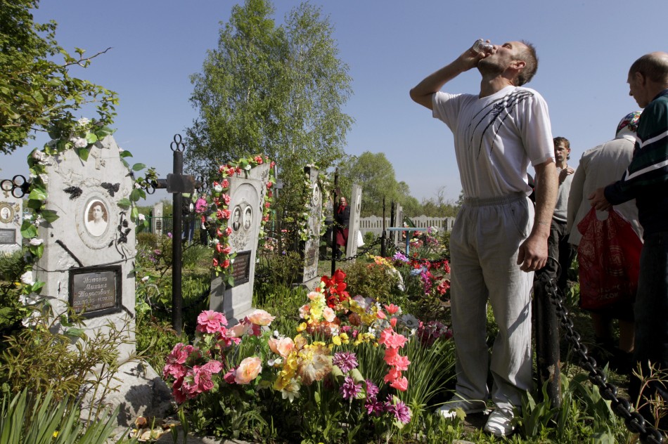 A man drinks vodka at a grave during Orthodox Easter in the village of Pogost, some 250 km 155 miles south of Minsk May 5, 2013. Villagers in southern parts of Belarus visit their relatives graves during Easter celebrations on Sunday.