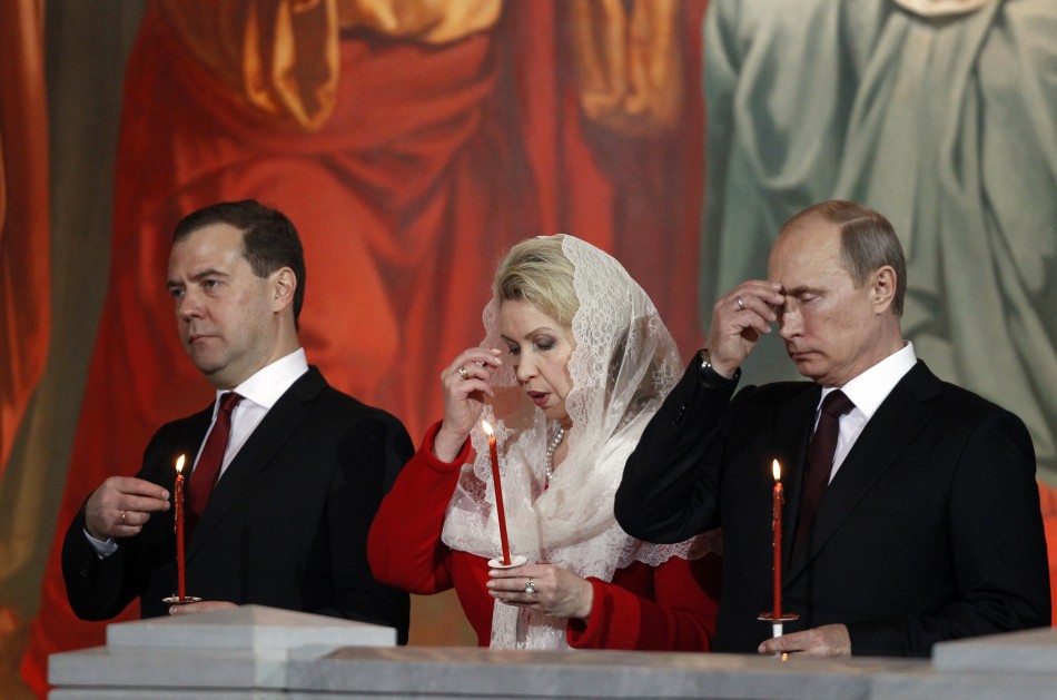 Russian President Vladimir Putin R, Prime Minister Dmitry Medvedev L and his wife Svetlana C attend an Orthodox Easter service conducted by the Patriarch of Moscow and All Russia Kirill in the Christ the Saviour Cathedral in Moscow May 5, 2013.
