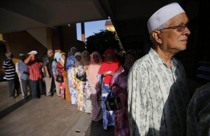 Voters queue up to cast their ballots during the general elections outside a polling station in Pekan, 300 km (186 miles) east of Kuala Lumpur May 5, 2013. Malaysians vote on Sunday in an election that could weaken or even end the rule of one of the world