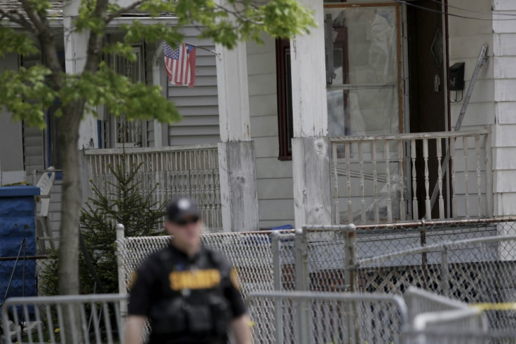 A police officer walks past the house where the three woman were held for a decade (Reuters)