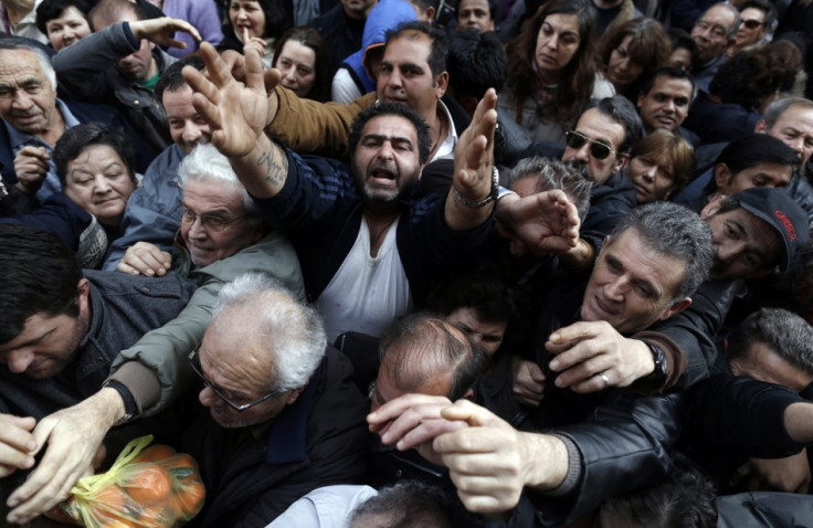 People reach out to take fruits and vegetables freely distributed by farmers during a protest against high production costs outside the Agriculture Ministry in Athens February 6, 2013 (Photo: Reuters)