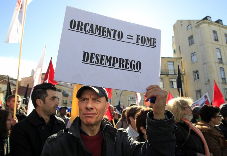 A man holds a sign reading: "Budget = hunger, unemployment" during an anti-austerity protest in front of Portugal's parliament in Lisbon November 27, 2012. (Photo: Reuters)