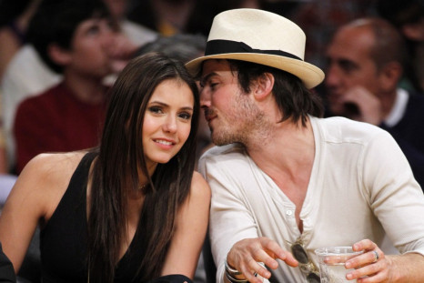 Canadian actress Nina Dobrev (L) sits court side with actor Ian Somerhalder