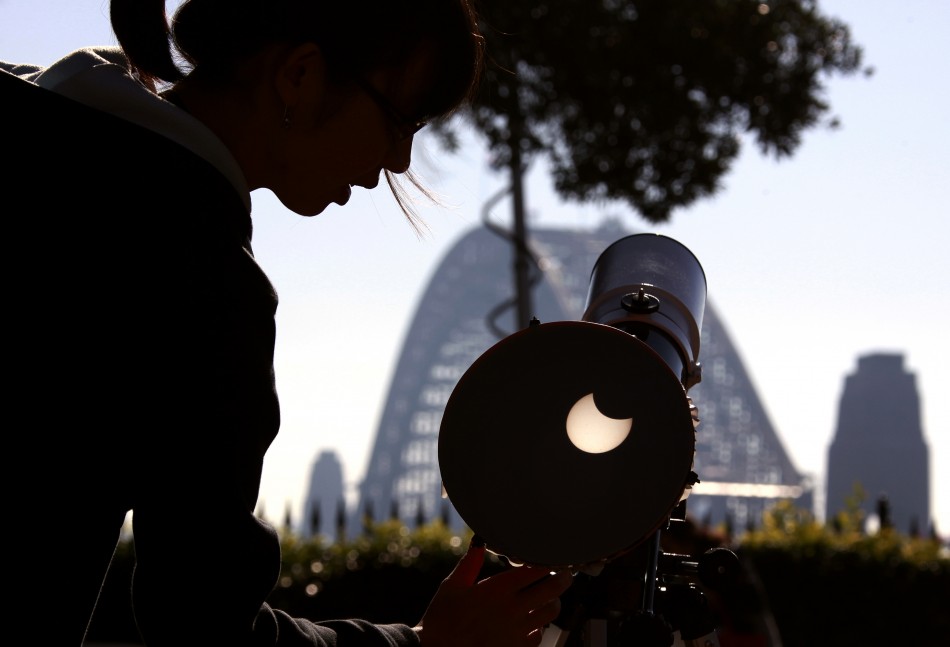 A woman adjusts a telescope showing on a screen the annular solar eclipse from atop Observatory Hill in Sydney May 10, 2013.