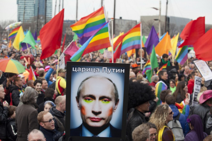 A demonstrator holds up a picture depicting Russian President Vladimir Putin with make-up,