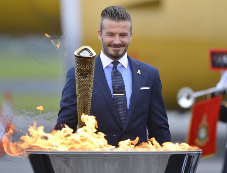 Soccer player and London 2012 Olympic Games ambassador David Beckham reacts after lighting the Olympic torch with a cauldron after arriving at RNAS Culdrose base near Helston in Cornwall, south west England May 18, 2012.