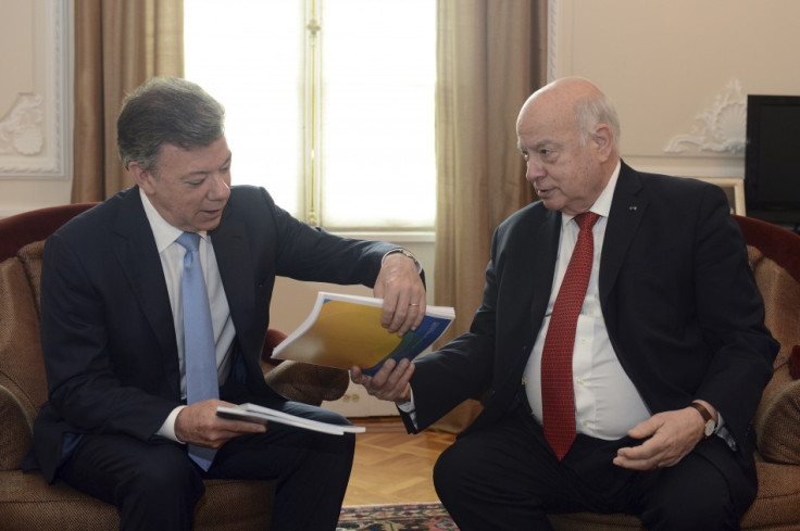Colombia's President Juan Manuel Santos (L) receives a document from Jose Miguel Insulza, General Secretary of the Organization for the American States (OAS), during a meeting at presidential palace in Bogota May 17, 2013. Insulza Santos presented a repor