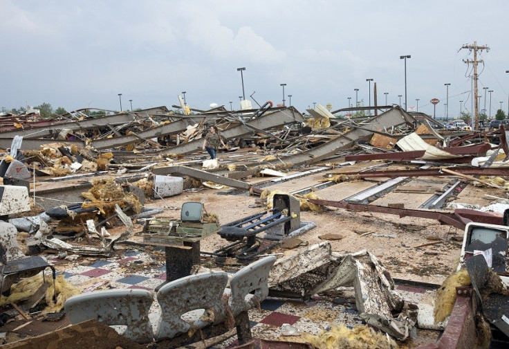 A woman walks through debris after a huge tornado struck Moore, Oklahoma (Reuters)