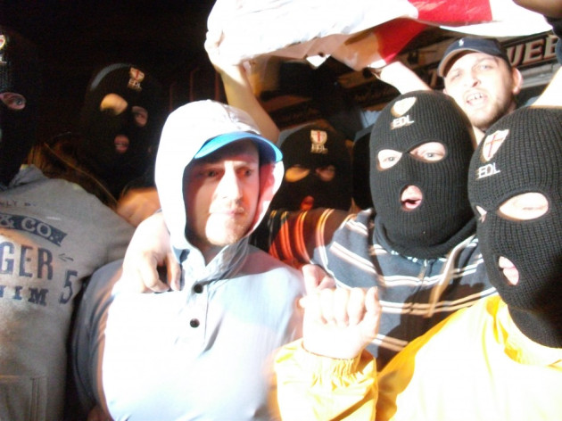 Tommy Robinson in light hoodie flanked by EDL supporters Tommy Robinson in light hoodie flanked by EDL supporters