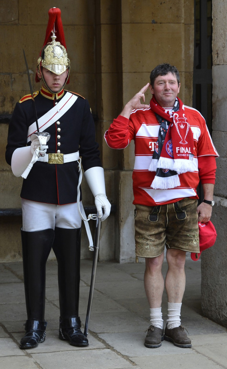 A Bayern Munich supporter poses next to a member of The Queen's Life Guard standing on duty outside of Horse Guards in central London