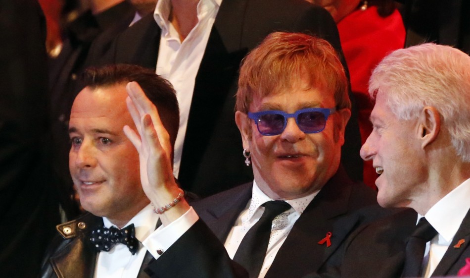 British singer Elton John C and his partner David Furnish L listen to former U.S. President Bill Clinton R during the opening ceremony of the 21st Life Ball in Vienna