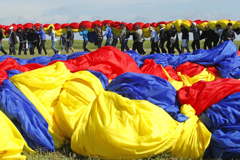 Workers carry Romanias national flag during a Guinness World Record attempt for the worlds biggest national flag in Clinceni, near Bucharest May 27, 2013.