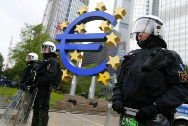 Riot police stand near the euro sign in front of the European Central Bank