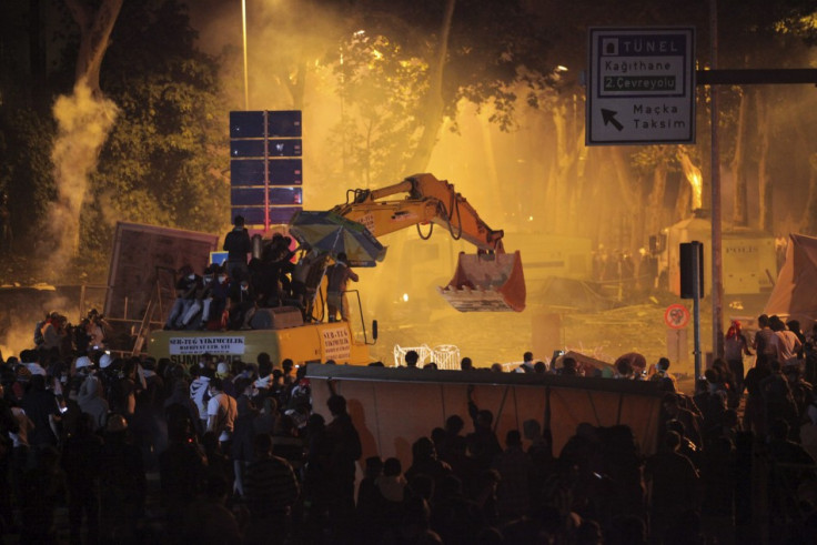 Anti-government protesters behind barricades and on an excavator clash with riot police as they try to march to the office of Turkey's Prime Minister Tayyip Erdogan