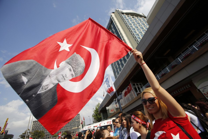 A demonstrator waves a Turkish flag with a portrait of Mustafa Kemal Ataturk during an anti-government protest