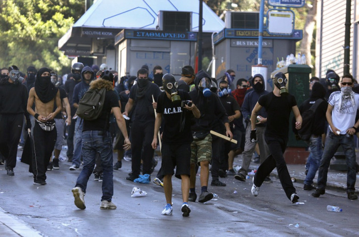 Hooded youths move towards riot police in Athens' Syntagma square during a 24-hour labour strike September 26, 2012. Greek police fired teargas at hooded youths hurling petrol bombs and stones as tens of thousands took to the streets in Greece's biggest a