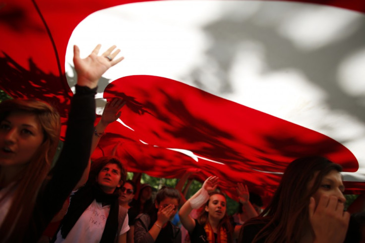 Protesters carry the Turkish flag and shout anti-government slogans