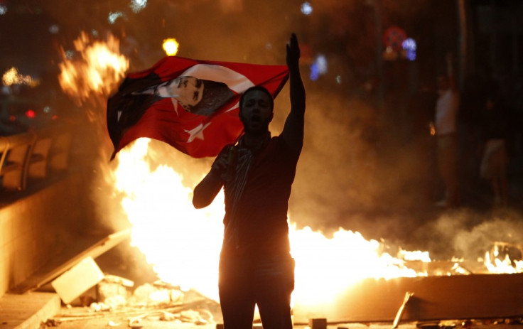 An anti-government protester holds a Turkish national flag with a portrait of Mustafa Kemal Ataturk