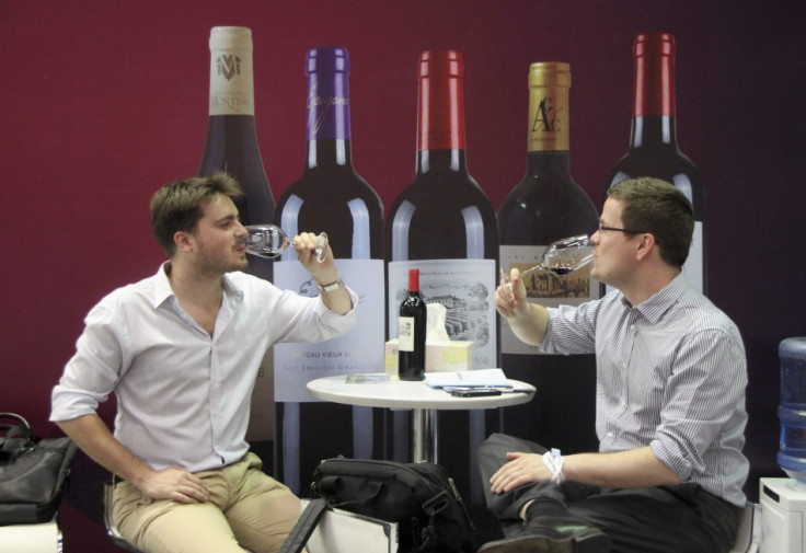 People taste French wine at a wine expo in Beijing
