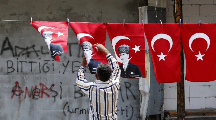A man displays Turkey's national flags and flags printed with portraits of Mustafa Kemal Ataturk
