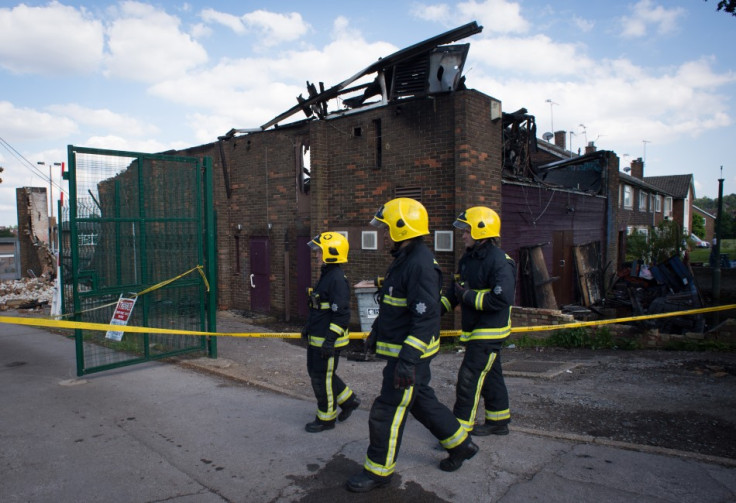 Firefighers walk past the Somali Bravanese Welfare Association in north London (Reuters)