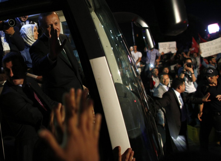 Turkey's Prime Minister Tayyip Erdogan (2nd L) waves to supporters after arriving at Istanbul's Ataturk airport