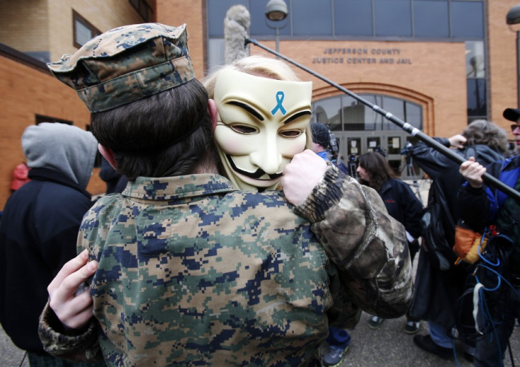 Two protesters hug after hearing the verdict in the trial of Trent Mays and Ma'lik Richmond outside the juvenile court in Steubenville, Ohio (Reuters)