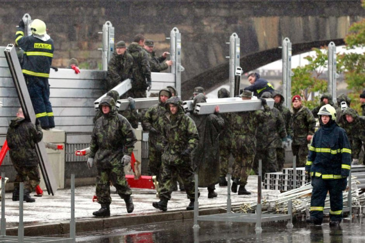 Hundreds of soldiers and volunteers drafted in to build barriers and reinforce dykes against the rising flood water