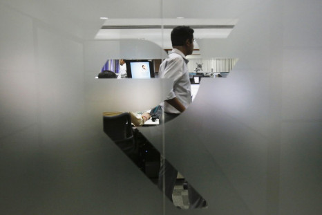 A currency trader is pictured through the symbol for the Indian Rupee on the floor of a trading firm in Mumbai, in May, 2013. (Reuters)