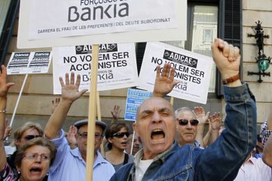 Junior debt holders of Bankia take part in a protest outside Spain's regional government office in Barcelona June 6, 2013. The signs read, "We don't want to be Bankia's forced holders". (Photo: REUTERS)