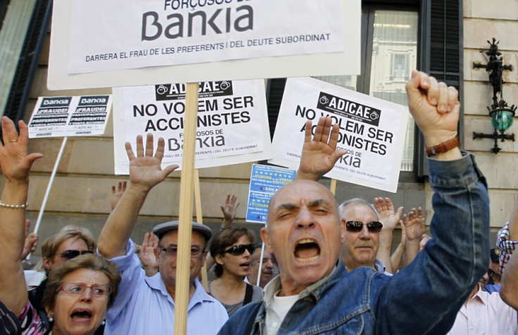 Junior debt holders of Bankia take part in a protest outside Spain's regional government office in Barcelona June 6, 2013. The signs read, "We don't want to be Bankia's forced holders". (Photo: REUTERS)