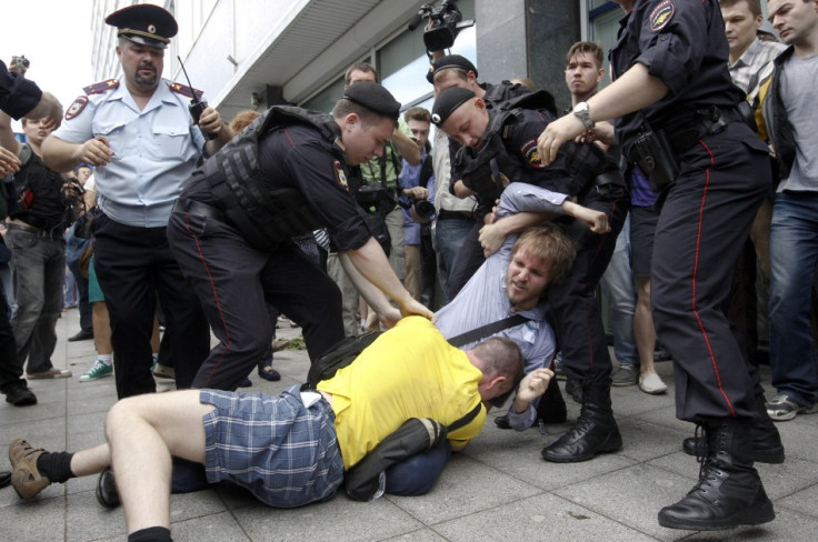 Policemen break up a fight between a gay rights activist and an anti-gay rights activist (in yellow) during a protest against a proposed new law (Reuters)
