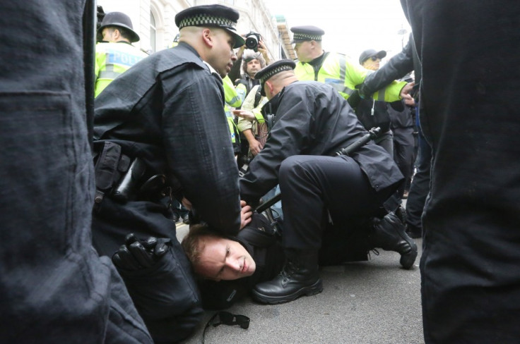 Police officers detain a protester demonstrating against the upcoming G8 summit (Reuters)