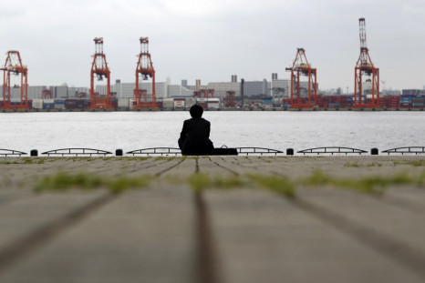 a businessman sitting near a cargo area at a port in Tokyo