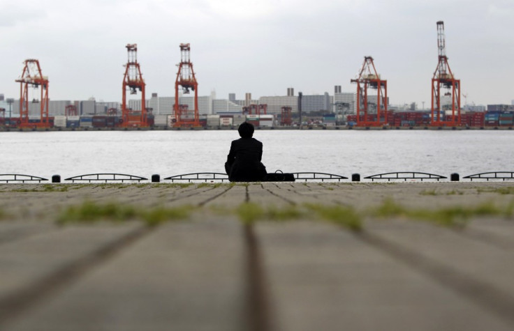 a businessman sitting near a cargo area at a port in Tokyo