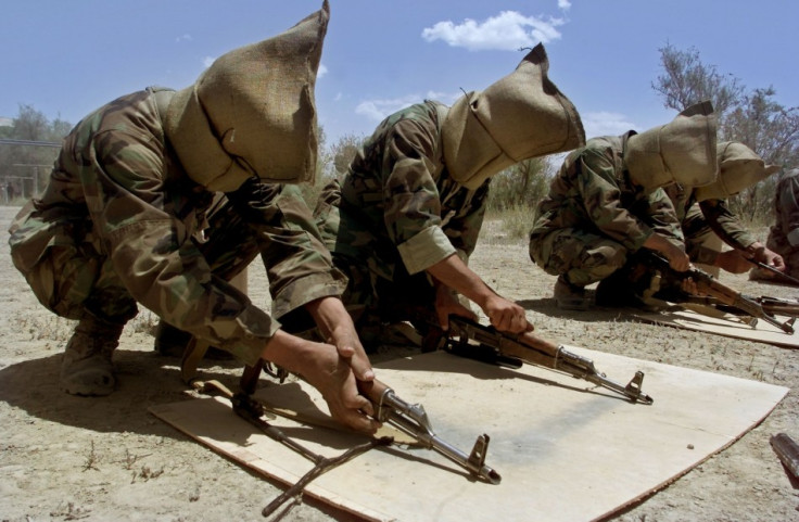 Afghan soldiers with sacks on their heads disassemble their machineguns during training by U.S.special forces