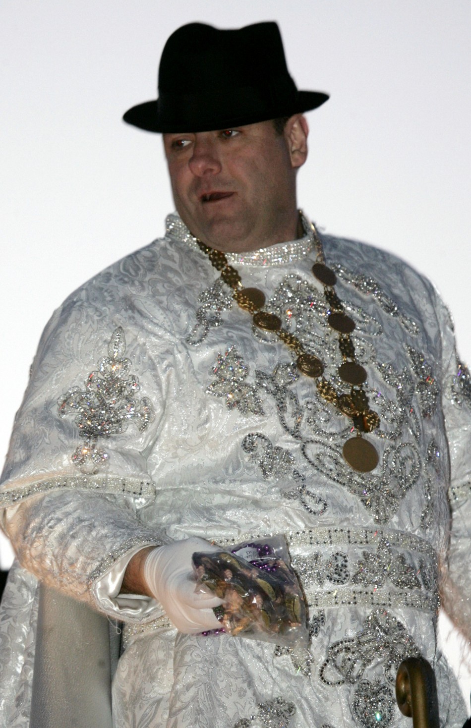 James Gandolfini, in unfamiliar getup, throws beads to revellers at a New Orleans street parade