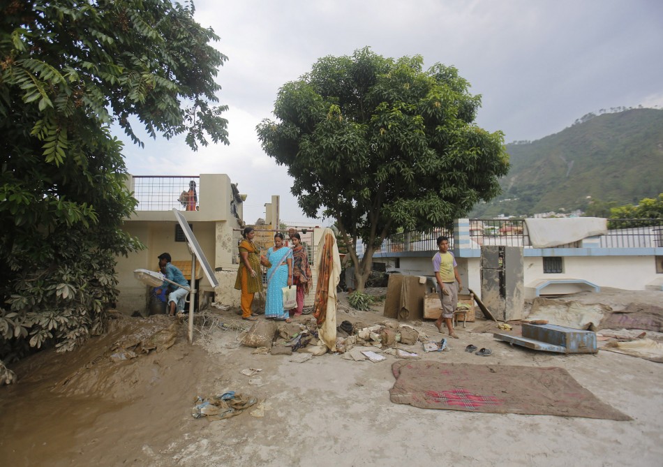 Residents take out their personal belongings from houses submerged in sand due to floods in Srinagar in the Himalayan state of Uttarakhand June 19, 2013.
