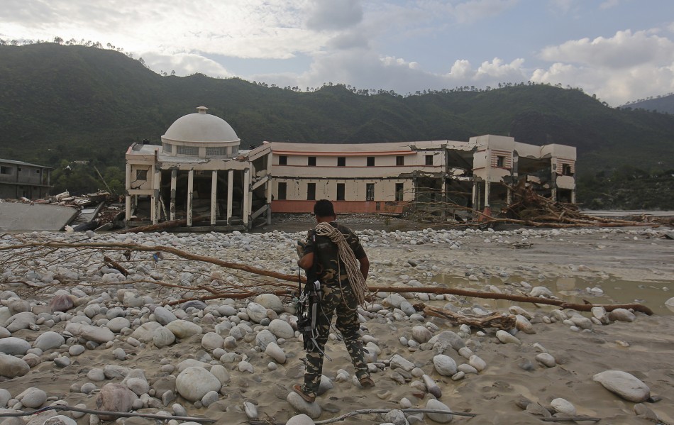 A member of the rescue operation team of Sashastra Seema Bal SSB or Armed Border Force walks towards the officers training centre damaged by floods at their campus in Srinagar in the Himalayan state of Uttarakhand June 19, 2013.
