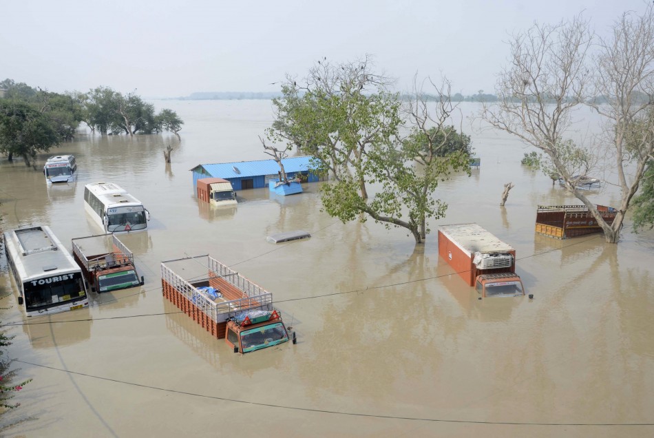 Vehicles are submerged in the rising waters of river Yamuna in New Delhi June 19, 2013.