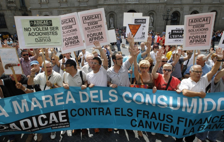 People take part in a protest against banking system in front of Generalitat Catalunya Palace (regional government) in Barcelona June 22, 2013. The banner reads, "Consumer tide". (Photo: REUTERS)
