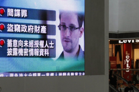 A monitor broadcasts news on the charges against Edward Snowden