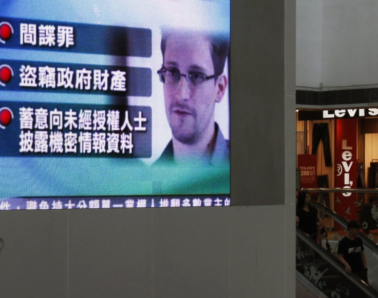 A monitor broadcasts news on the charges against Edward Snowden