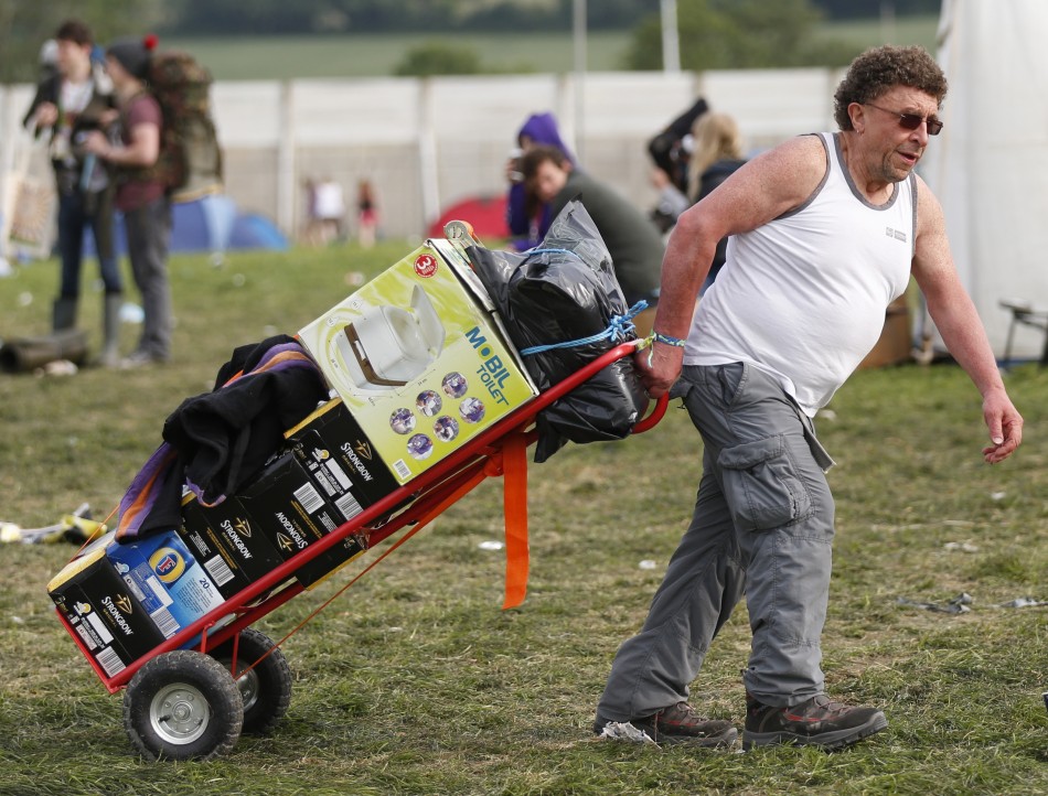 A festival goer wheels in a mobile toilet and crates of beer