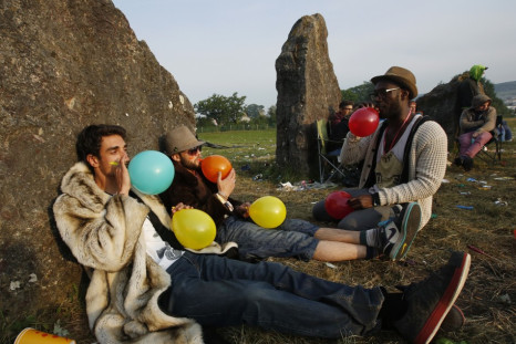 Festival goers inhale laughing gas at sunrise at the stone circle