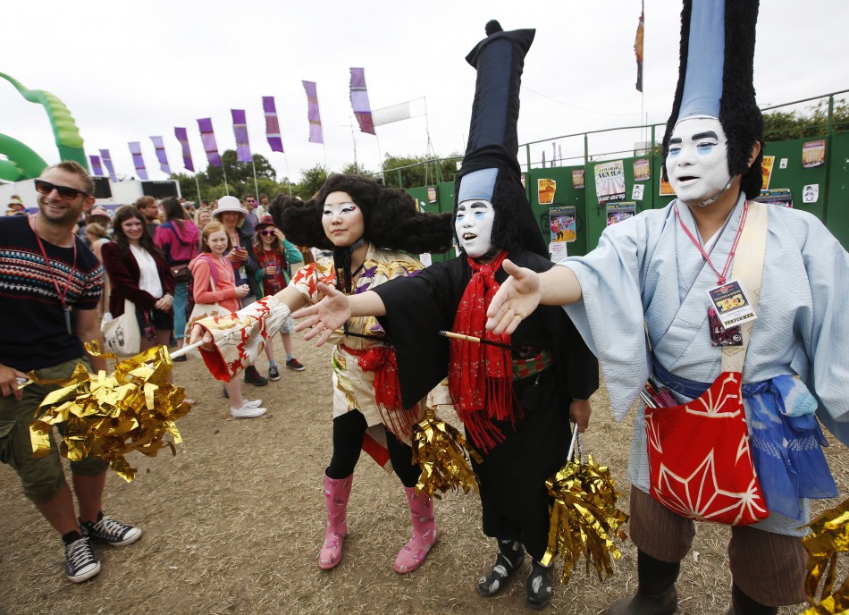 Japanese performance artists Masanori Takeuchi shake hands with festival goers