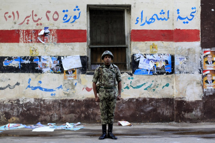 An Egyptian soldier stands guard in front of a polling station in Cairo