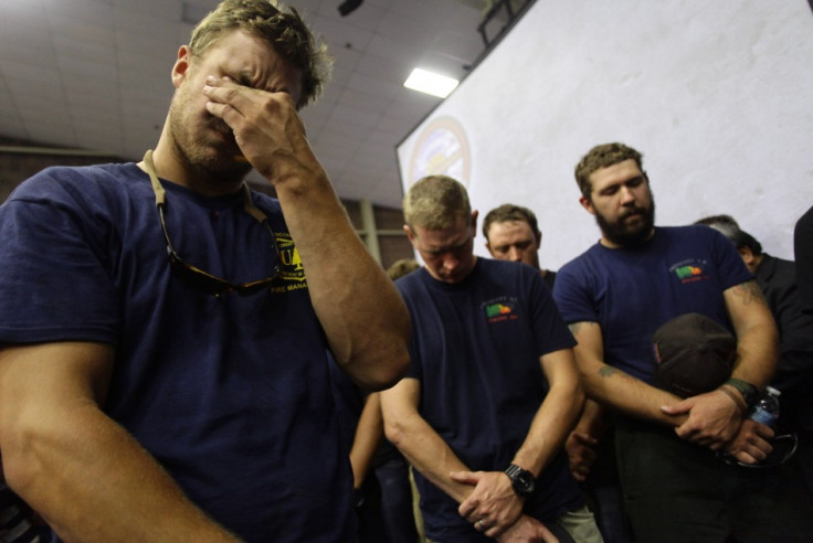 Hotshot firefighters mourn during a moment of silence for the 19 firefighters who died in the fast-moving fire (Reuters)