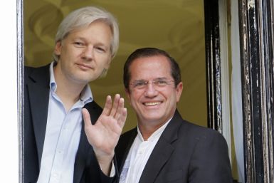 WikiLeaks founder Julian Assange waves from a window with Ecuador's Foreign Affairs Minister Ricardo Patino (R) at Ecuador's embassy