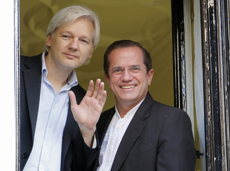 WikiLeaks founder Julian Assange waves from a window with Ecuador's Foreign Affairs Minister Ricardo Patino (R) at Ecuador's embassy